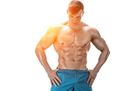 Strong Athletic Man showing muscular body and sixpack abs isolated on white background. with sun flareの写真素材
