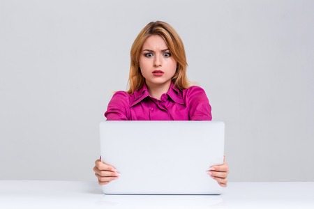 Young businesswoman working at laptop computer. she was surprised, prints and looking at monitorの写真素材