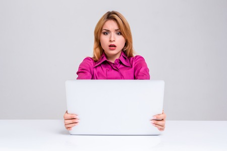 Young businesswoman working at laptop computer. she was surprised, prints and looking at monitorの写真素材