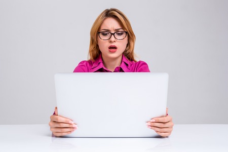 Young businesswoman working at laptop computer. she was surprised, prints and looking at monitorの写真素材