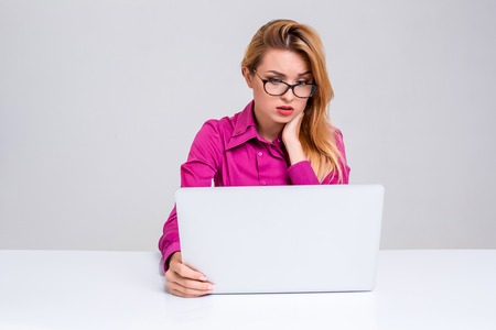 Young businesswoman working at laptop computer. she was tired and looking at monitorの写真素材