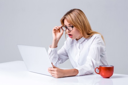 Young businesswoman working at laptop computer. she was surprised, prints and looking at monitorの写真素材