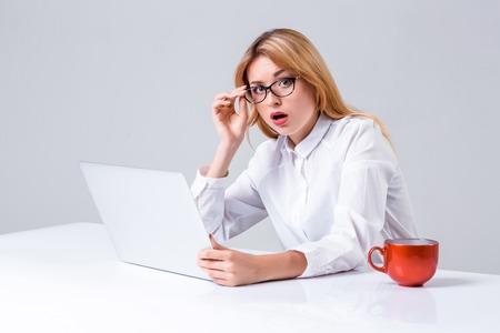Young businesswoman working at laptop computer. she was surprised, prints and looking at cameraの写真素材