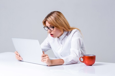 Young businesswoman working at laptop computer. she was surprised, prints and looking at monitorの写真素材