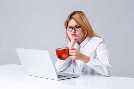 Young businesswoman working at laptop computer. she was tired, prints and looking at monitorの写真素材