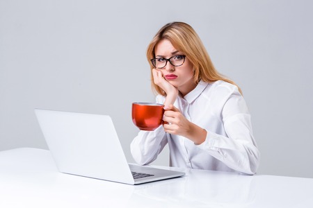 Young businesswoman working at laptop computer. she was tired, prints and looking at monitorの写真素材