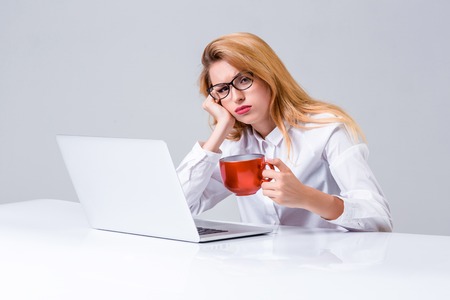 Young businesswoman working at laptop computer. she was tired, prints and looking at monitorの写真素材