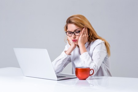 Young businesswoman working at laptop computer. she was tired, prints and looking at monitorの写真素材