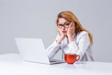 Young businesswoman working at laptop computer. she was tired, prints and looking at monitorの写真素材