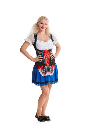 Beautiful young blond girl in dirndl drinks out of oktoberfest beer stein. Isolated on white background. It is a full-length.の写真素材