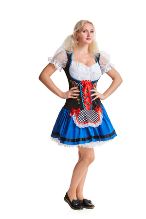 Beautiful young blond girl in dirndl drinks out of oktoberfest beer stein. Isolated on white background. It is a full-length.の写真素材