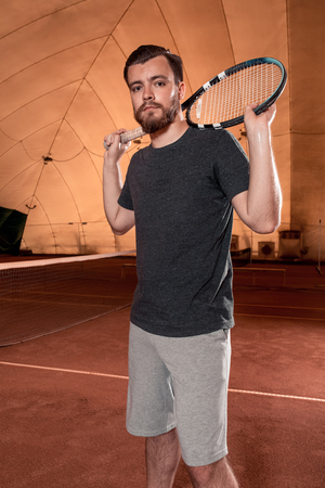 Successful sportsman with racket at the tennis court. Healthy lifestyleの写真素材