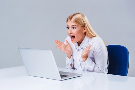 Young businesswoman working at laptop computer. surprised pleasedの写真素材