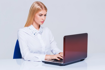 Young businesswoman working at laptop computer. Pretty smiling girlの写真素材