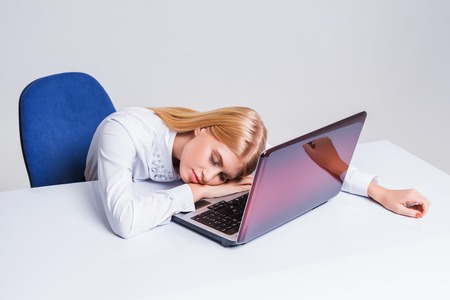 Young businesswoman working at laptop computer. tired girl soon fell asleep stressの写真素材