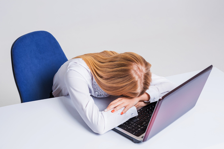 Young businesswoman working at laptop computer. tired girl soon fell asleep stressの写真素材