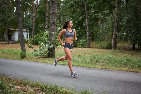 Young woman running outdoors in a city park on. motion blurred image color toned imageの写真素材