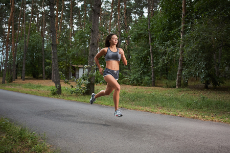 Young woman running outdoors in a city park on. motion blurred image color toned imageの写真素材