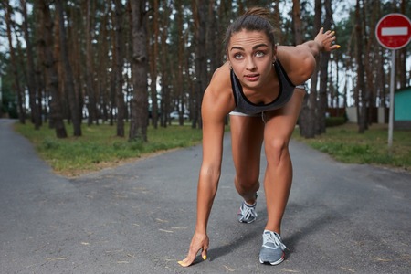 Young woman running outdoors in a city park on. It is preparing to startの写真素材
