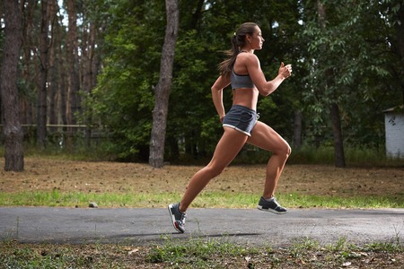 Young woman running outdoors in a city park on. motion blurred image color toned imageの写真素材