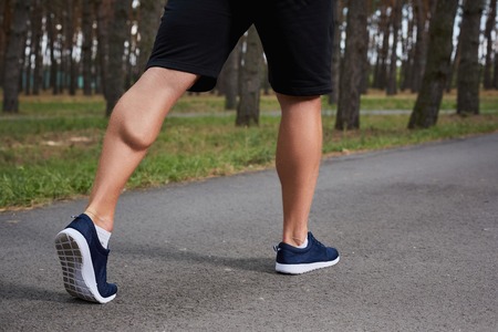 young athlete running in the forest, motion blur, feet close-upの写真素材