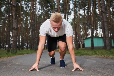 young athlete running in the forest, it is preparing to startの写真素材