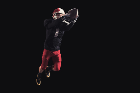 Soccer player on a dark background in vintage style. The classic American game. college Students. It makes the jumpの写真素材