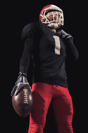Soccer player on a dark background in vintage style. The classic American game. college Studentsの写真素材