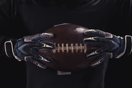 Soccer player on a dark background in vintage style. The classic American game. college Students. close-up ballの写真素材