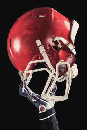 Soccer player on a dark background in vintage style. The classic American game. college Students. close-up helmetの写真素材