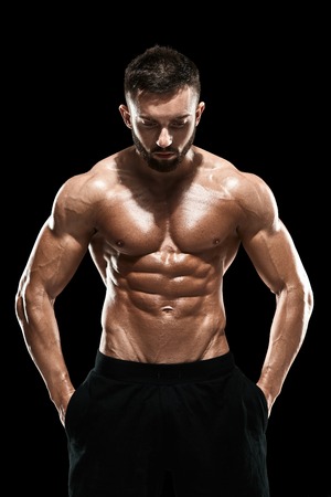 Muscular bodybuilder guy doing posing over black background.の写真素材