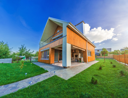 Beautiful wooden house with a lawn. Facade of traditional homes with grass in the foreground. at sunset and sunriseの写真素材