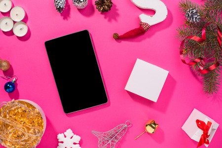 Smartphone with Christmas decorations. Christmas mock up template. View from above. pink backgroundの写真素材