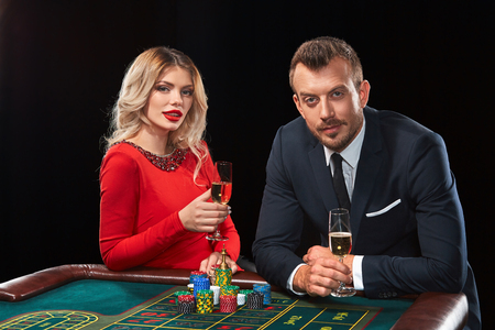 Couple playing roulette wins at the casino. Addiction to the gambling. celebrating the victory and winの写真素材