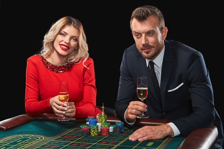 Couple playing roulette wins at the casino. Addiction to the gambling. celebrating the victory and winの写真素材