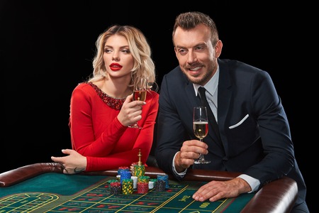 Couple playing roulette wins at the casino. Addiction to the gambling. celebrating the victory and winの写真素材