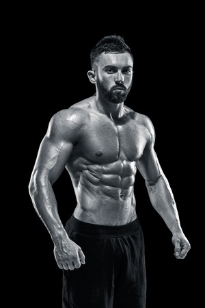 Muscular bodybuilder guy doing posing over black background.. Black and white colorの写真素材