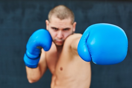 Boxer in blue gloves on the street. He looks into the camera. Beat in the cameraの写真素材