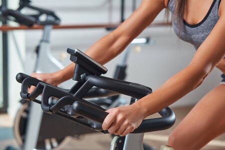 Strong female hand on a stationary bike in the gymの写真素材