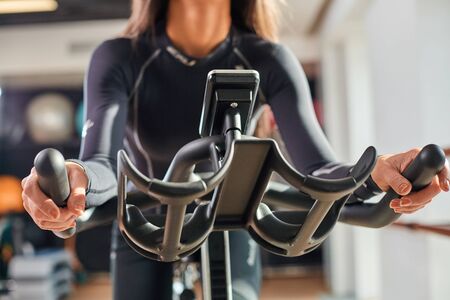 Strong female hand on a stationary bike in the gym