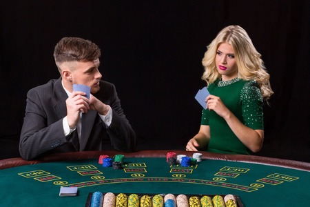 couple playing poker at the table. The blonde girl and a guy in a suit.の写真素材