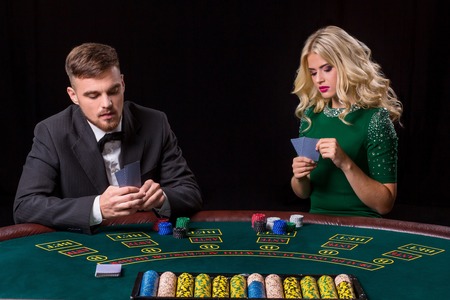 couple playing poker at the table. The blonde girl and a guy in a suit.の写真素材