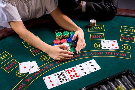 couple playing poker at the table. The blonde girl and a guy in a suit. close up hands. take chips wonの写真素材