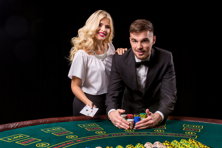 couple playing poker at the table. The blonde girl and a guy in a suit. happy winの写真素材