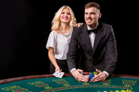couple playing poker at the table. The blonde girl and a guy in a suit. happy winの写真素材