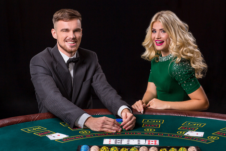 couple playing poker at the green table. The blonde girl and a guy in a suit. happy winの写真素材