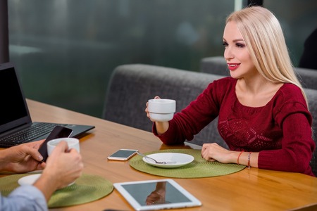A woman and a man on a business lunch in a restaurant, drink coffeeの写真素材
