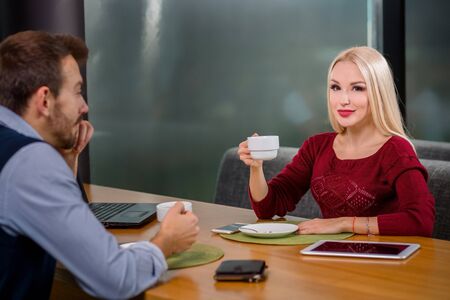 A woman and a man on a business lunch in a restaurant, drink coffeeの写真素材