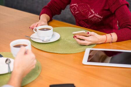 A woman and a man on a business lunch in a restaurant, drink coffee. Close upの写真素材