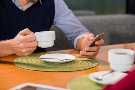 A woman and a man on a business lunch in a restaurant, drink coffee. Close upの写真素材